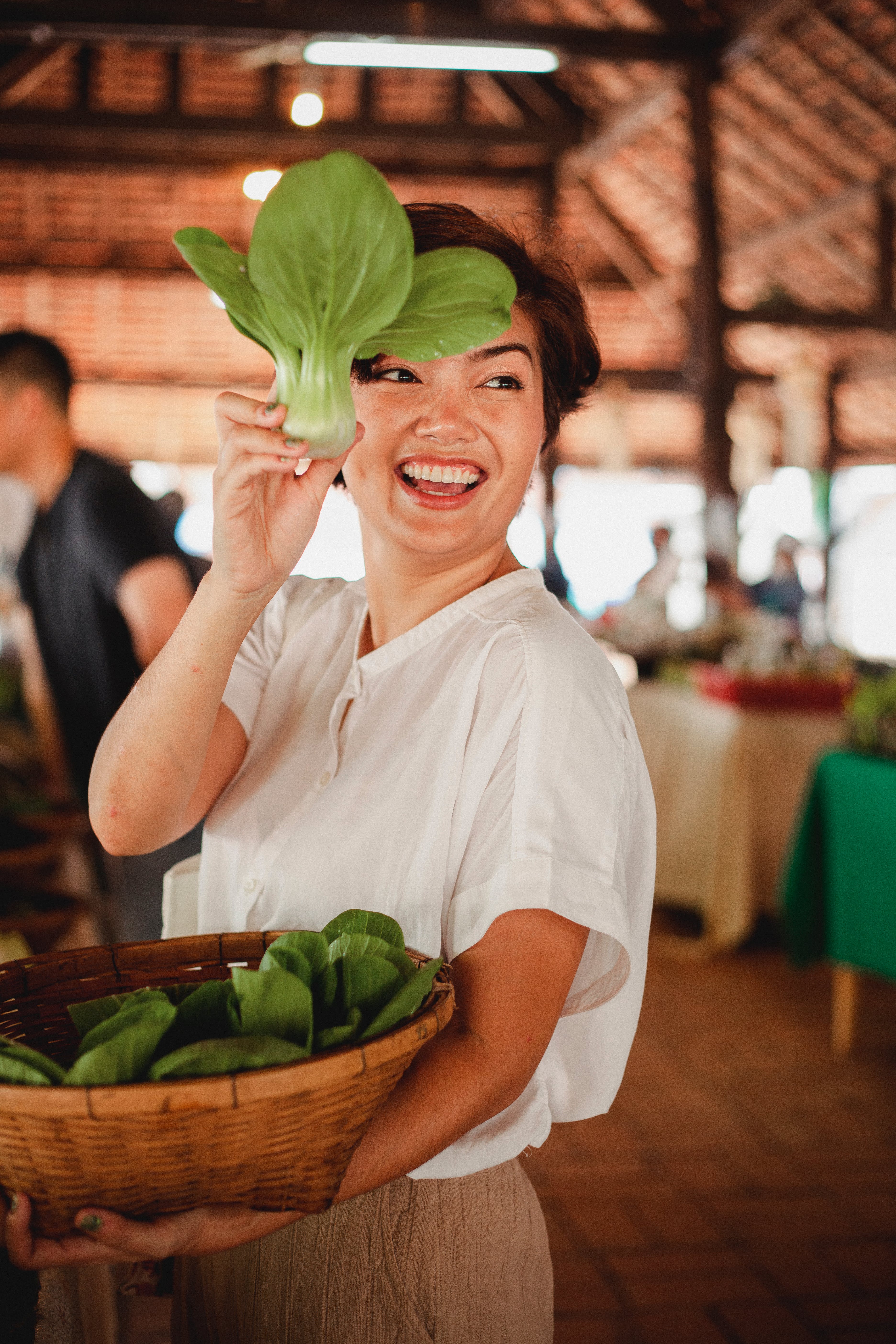 A woman proudly showing off her basket of parsley leaves.